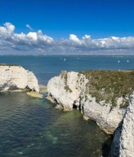 Old Harry Rocks chalk stacks rising from the sea under a blue sky