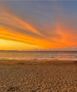 Orange sunset sky over a quiet sandy beach